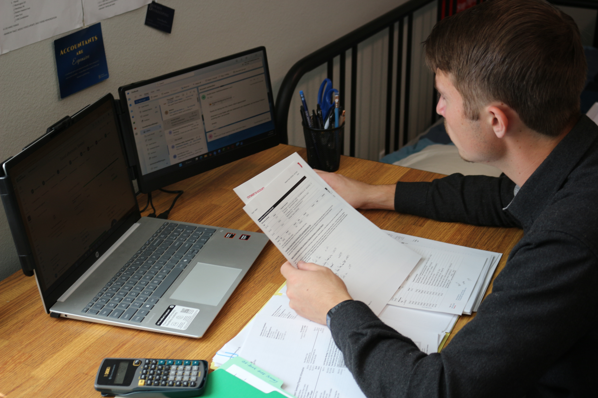 Simon Bowden reviewing financial statements at his workstation